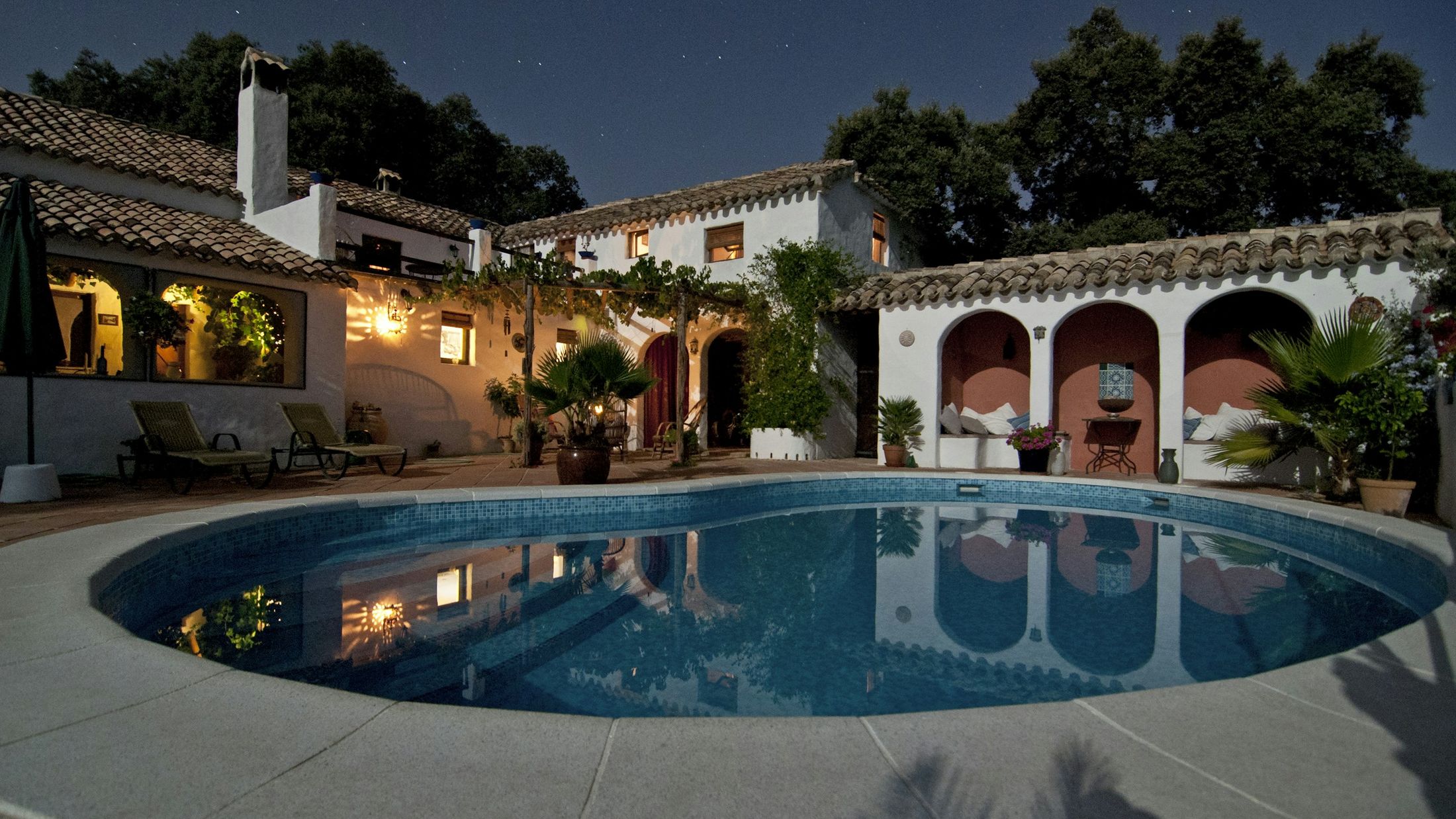 South Florida home lit at dusk around a courtyard pool