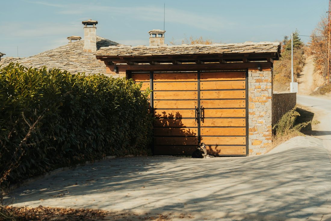 Cedar-slat garage door set into a stone facade